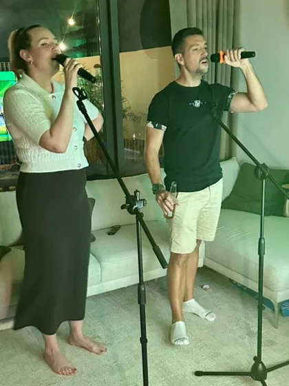 Two guests singing a duet at microphone stands