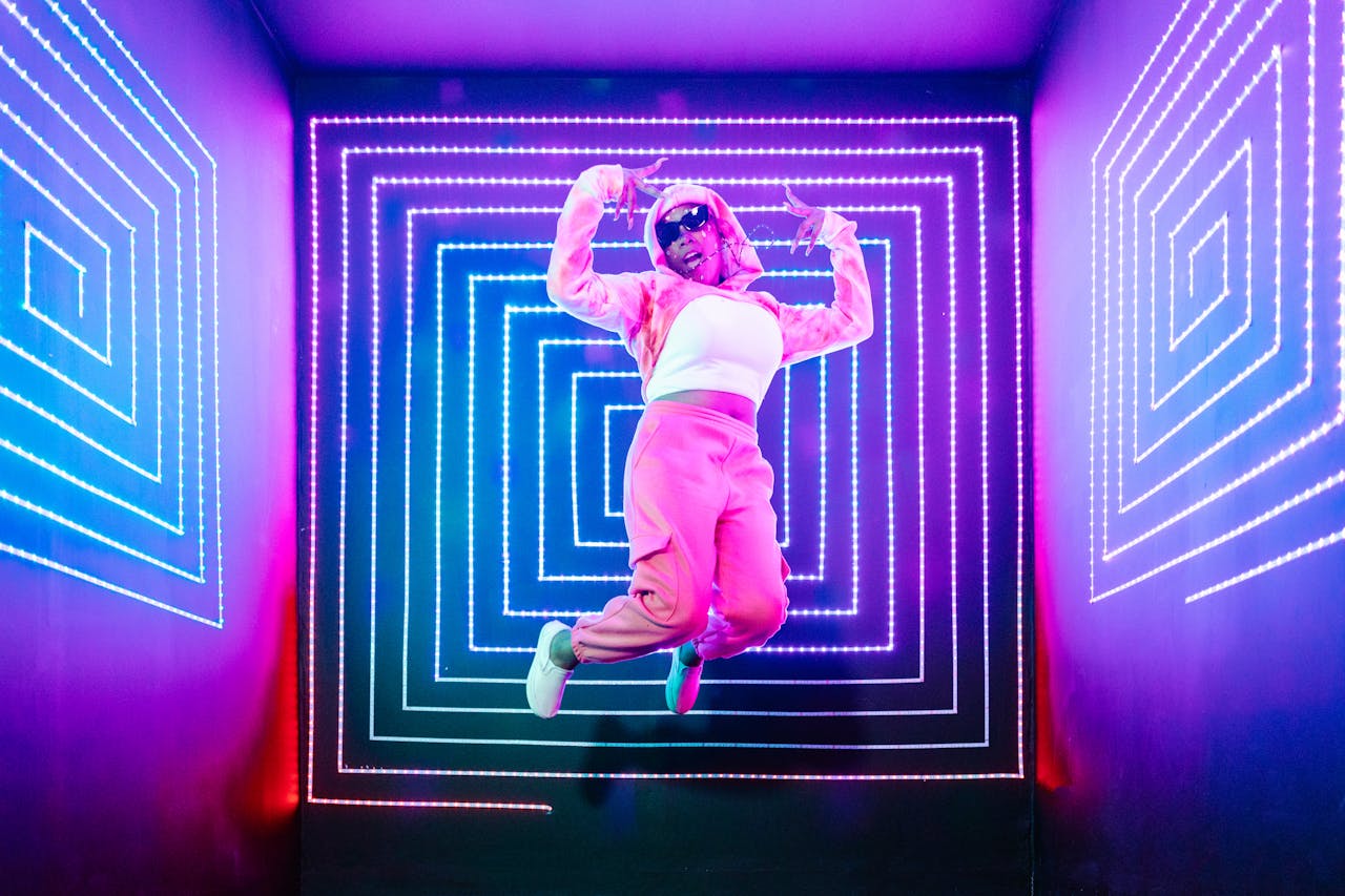 Person jumps energetically in a vibrant neon-lit environment, showcasing a fun and lively atmosphere.